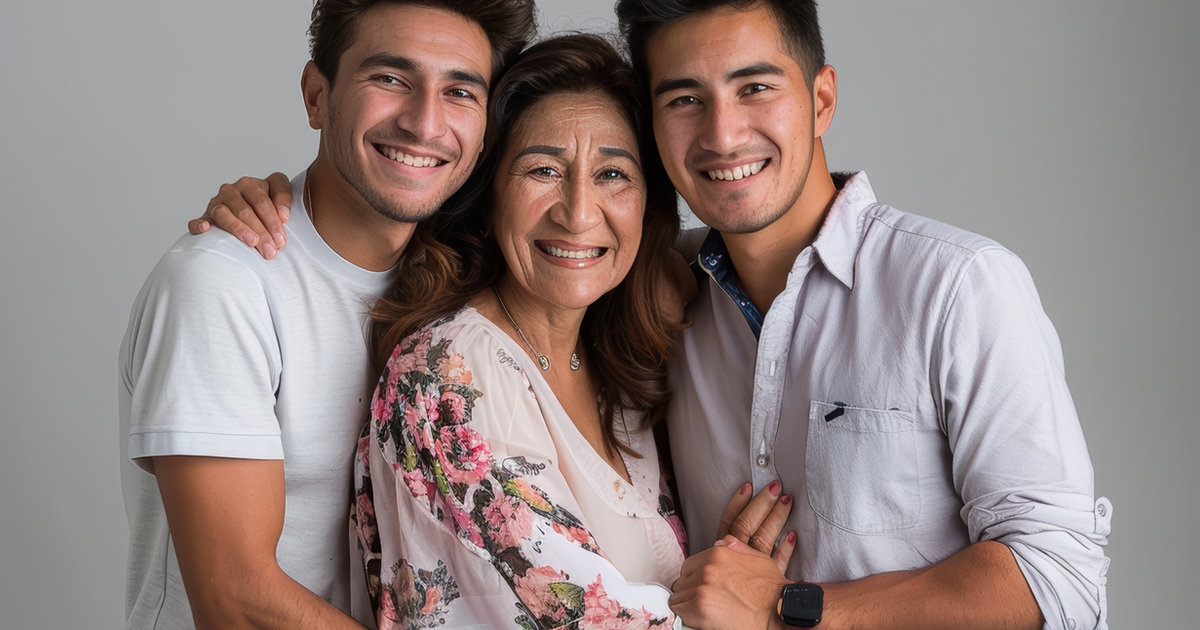 A smiling mother standing between her two grown children.