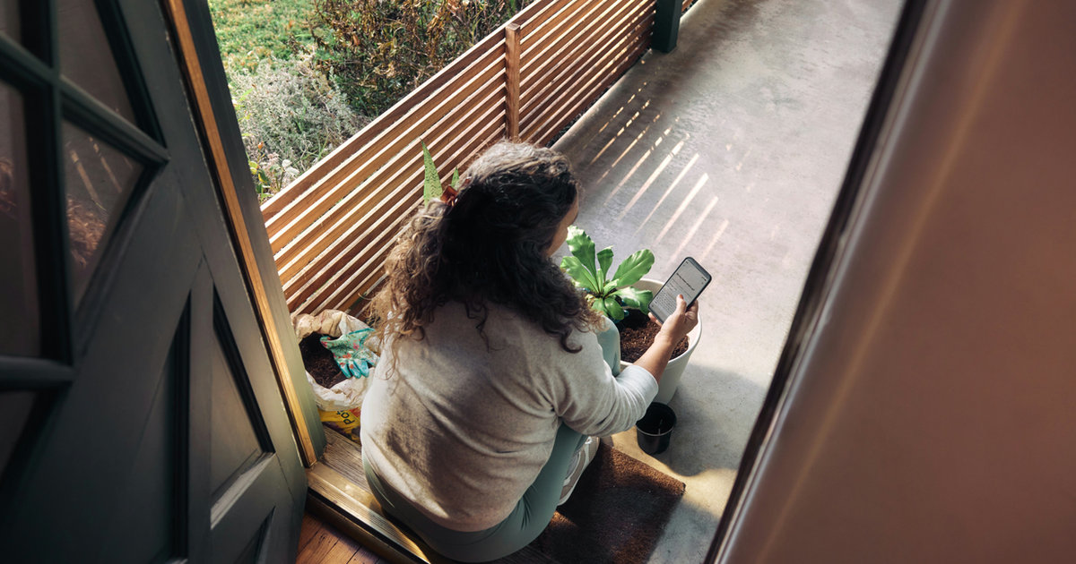 A person sitting alone by a window, looking outside.