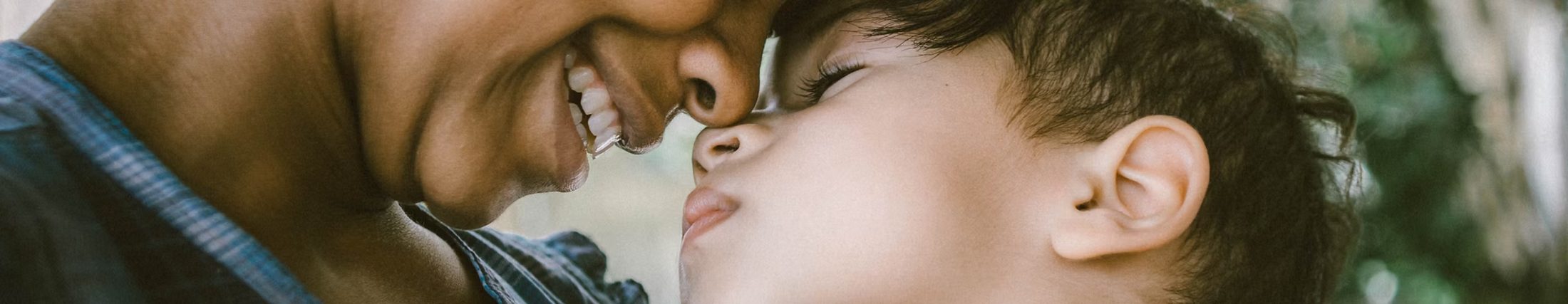 A mother and her child touching foreheads, smiling